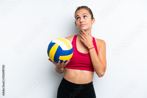 Young caucasian woman playing volleyball isolated on white background and looking up