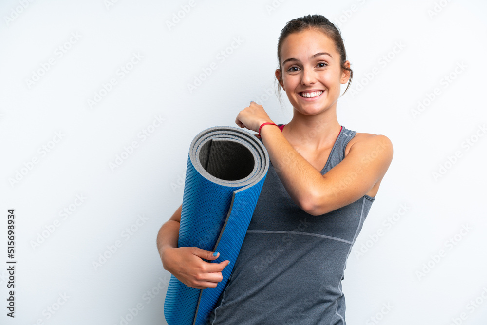Young sport woman going to yoga classes while holding a mat isolated on white background pointing back Young sport woman going to yoga classes while holding a mat isolated on white background pointing back