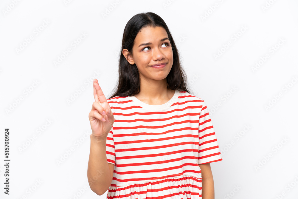 Young Colombian woman isolated on white background with fingers crossing and wishing the best Young Colombian woman isolated on white background with fingers crossing and wishing the best
