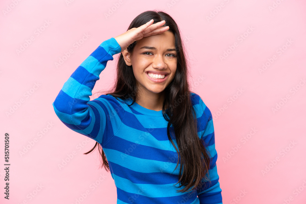 Young Colombian woman isolated on pink background looking far away with hand to look something Young Colombian woman isolated on pink background looking far away with hand to look something