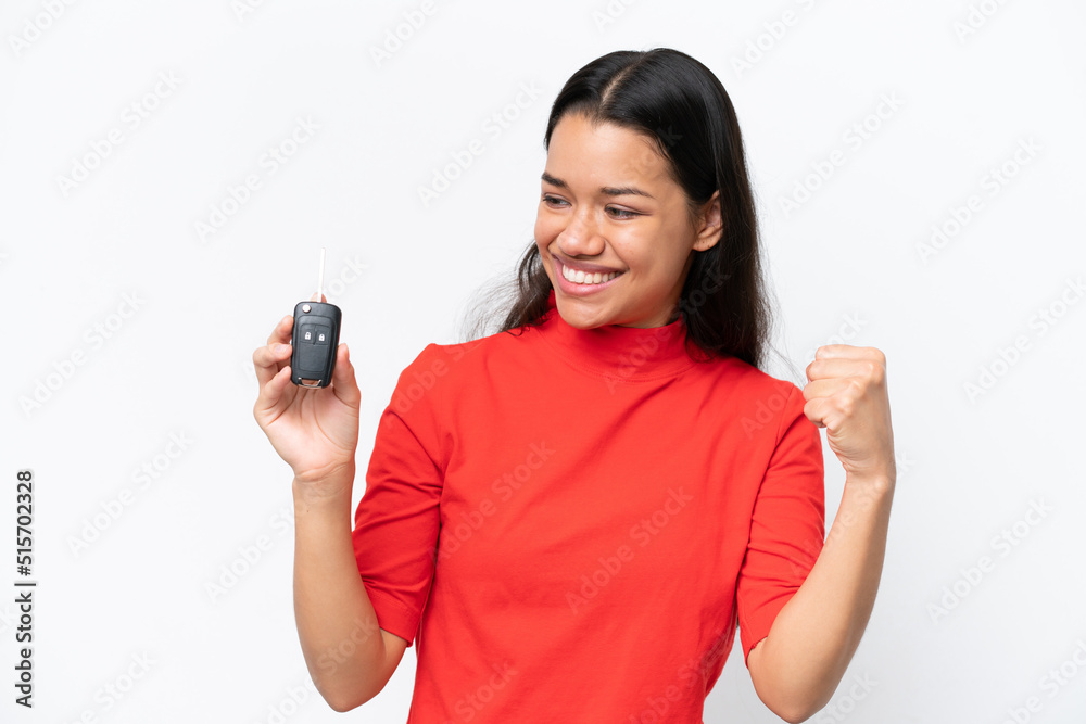 Young Colombian woman holding car keys isolated on white background celebrating a victory Young Colombian woman holding car keys isolated on white background celebrating a victory