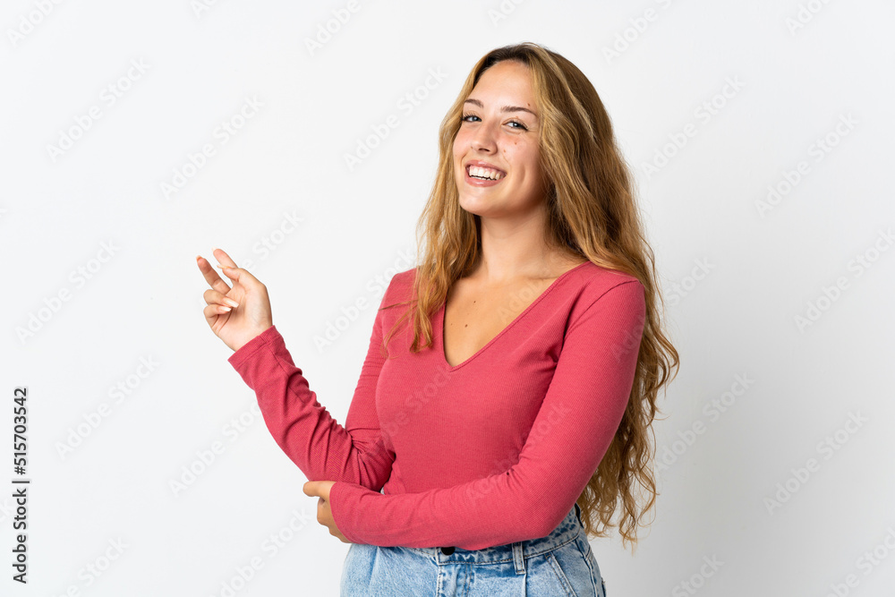 Young blonde woman isolated on blue background happy and pointing up Young blonde woman isolated on blue background happy and pointing up