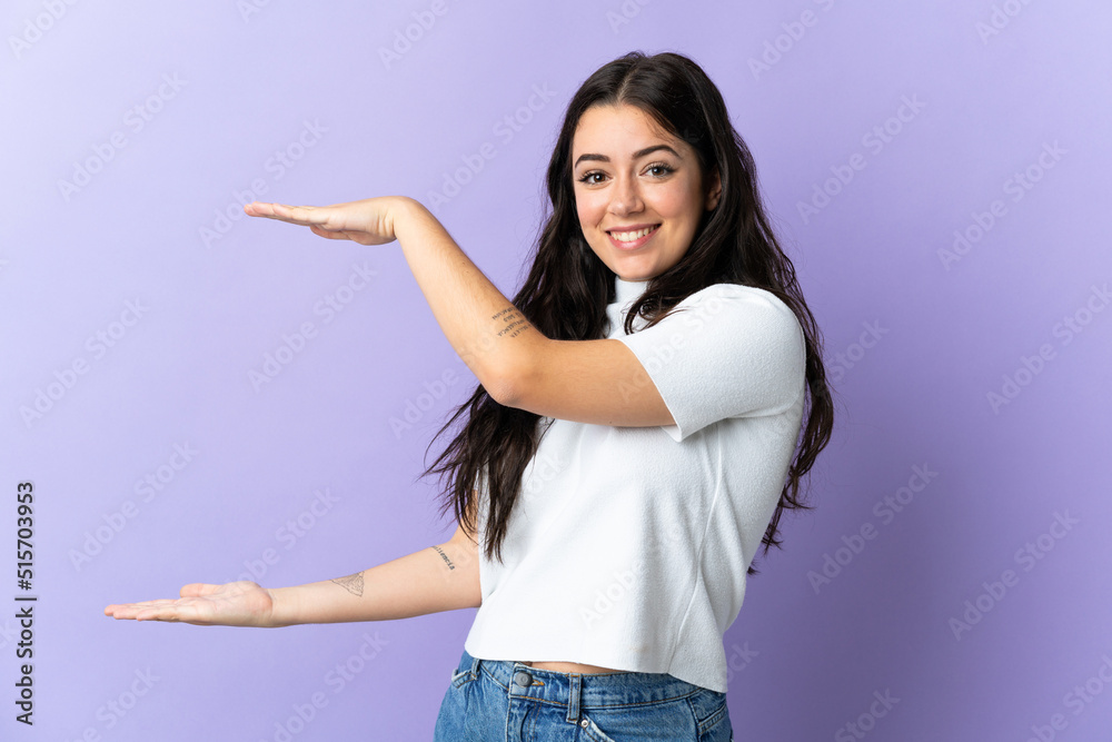 Young caucasian woman isolated on purple background holding copyspace to insert an ad Young caucasian woman isolated on purple background holding copyspace to insert an ad