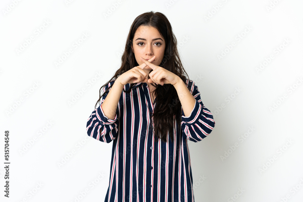 Young caucasian woman over isolated background showing a sign of silence gesture Young caucasian woman over isolated background showing a sign of silence gesture
