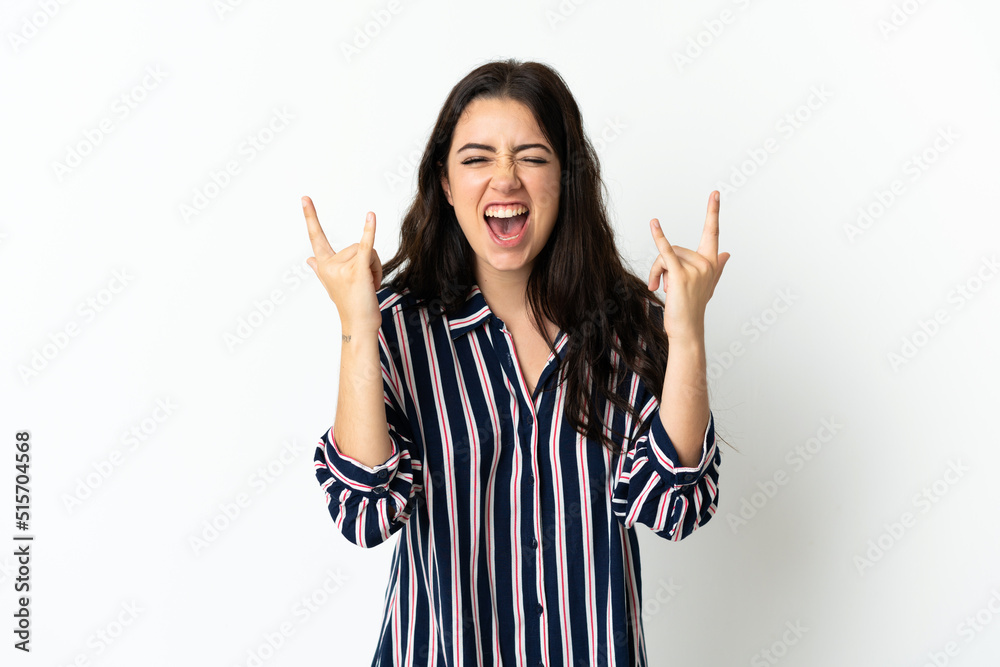 Young caucasian woman over isolated background making horn gesture Young caucasian woman over isolated background making horn gesture