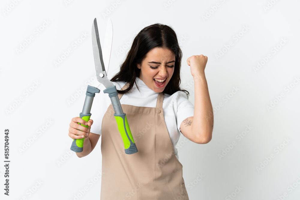 Young caucasian woman holding a plant isolated on white background celebrating a victory Young caucasian woman holding a plant isolated on white background celebrating a victory