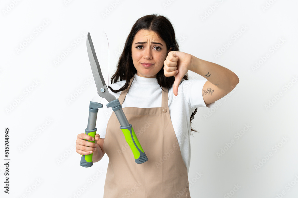 Young caucasian woman holding a plant isolated on white background showing thumb down with negative expression Young caucasian woman holding a plant isolated on white background showing thumb down with negative expression