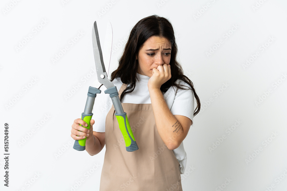Young caucasian woman holding a plant isolated on white background having doubts Young caucasian woman holding a plant isolated on white background having doubts