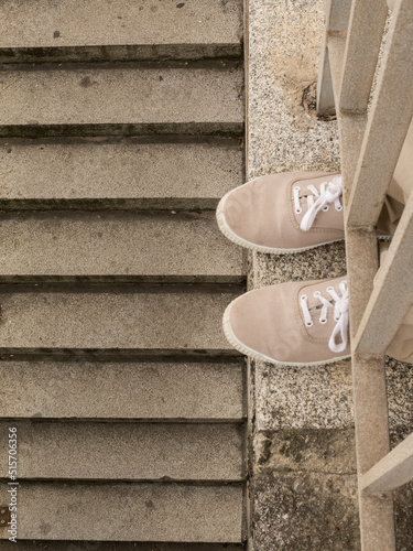 Stone stairs and iron railing with brown laceup sneakers photo