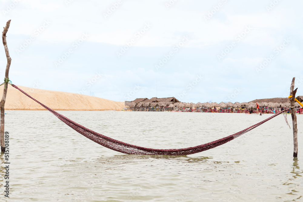 Obraz premium Resting in a hammock on the edge of the tatajuba lagoon in jericoacoara ceará brazil. Traditional hammock in the sea in Jeri. Rest hammock concept. vacation rest concept.