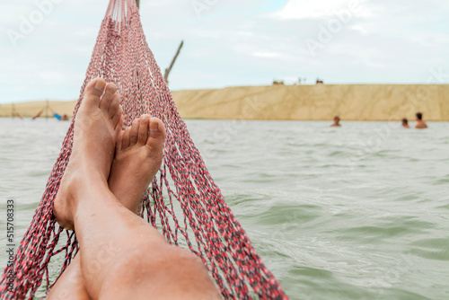 Resting in a hammock on the edge of the tatajuba lagoon in jericoacoara ceará brazil. Traditional hammock in the sea in Jeri. Rest hammock concept. vacation rest concept. photo