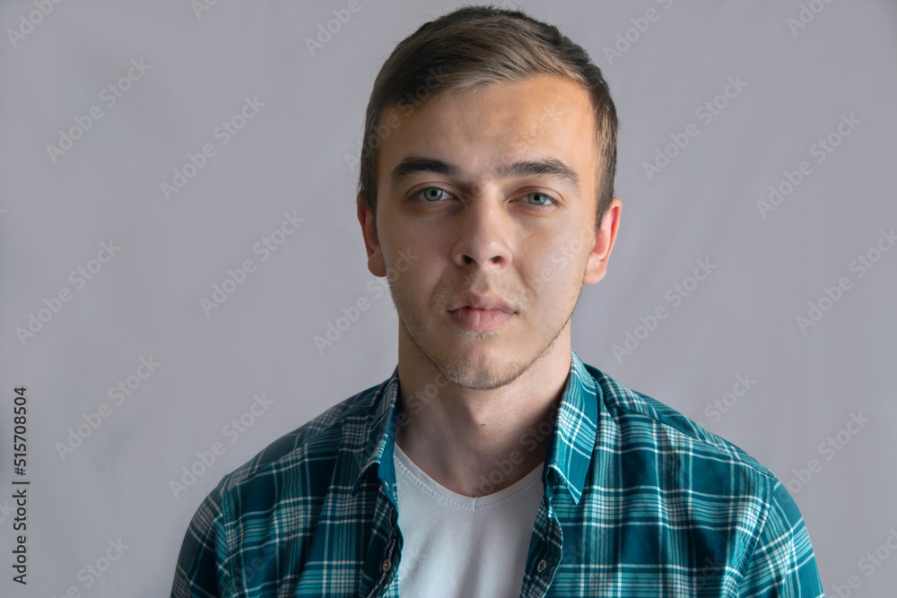 Serious young man. Portrait of handsome young man in casual shirt against grey background Serious young man. Portrait of handsome young man in casual shirt against grey background