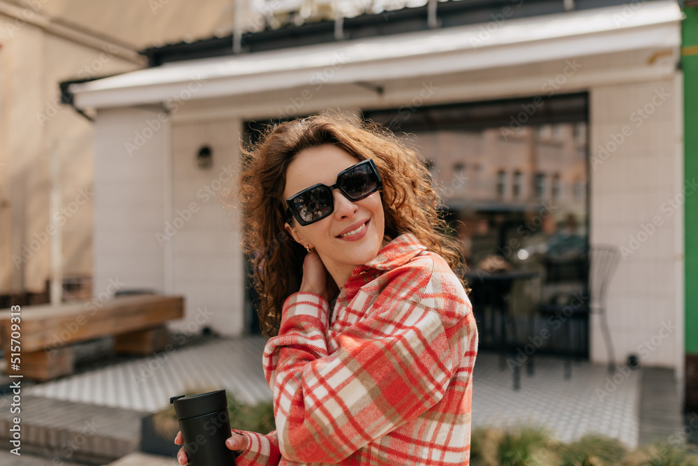 Outdoor close up portrait of lovely cute lady with dark wavy hair in sunglasses posing at camera. Interested caucasian woman posing on the street with lovely smile Outdoor close up portrait of lovely cute lady with dark wavy hair in sunglasses posing at camera. Interested caucasian woman posing on the street with lovely smile