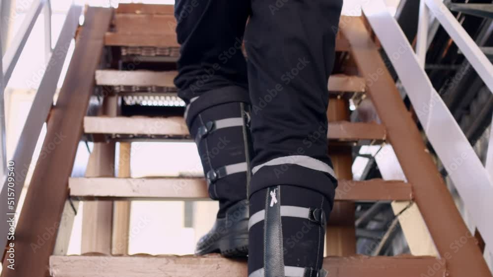 Vidéo Stock Closeup view of a worker in boots who climbs an iron ladder. Climbing stairs rear