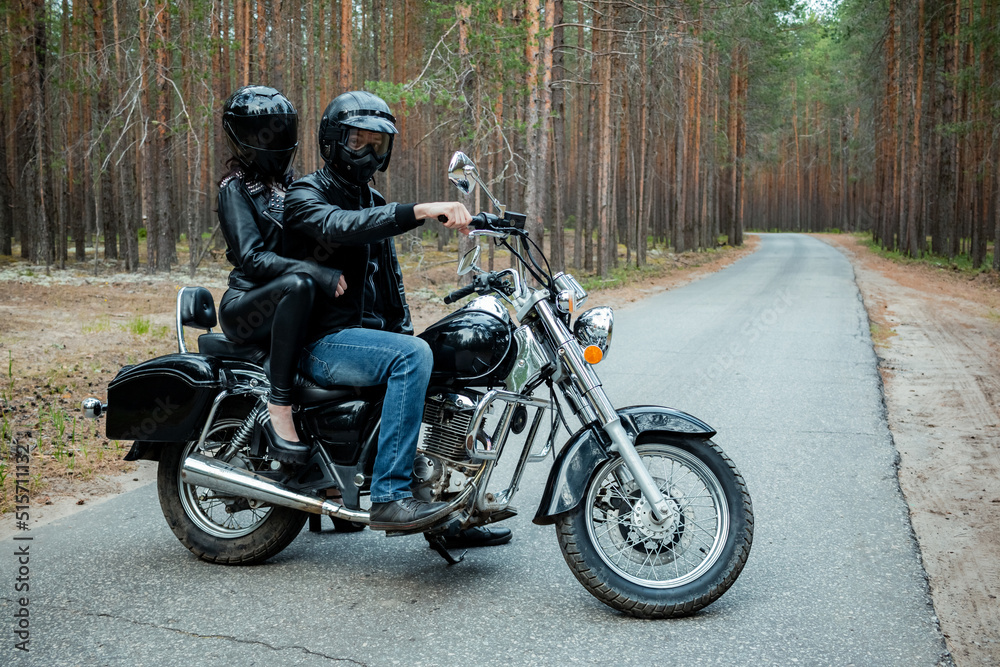 Young couple in black leather clothes on a vintage motorcycle. Young couple in black leather clothes on a vintage motorcycle.