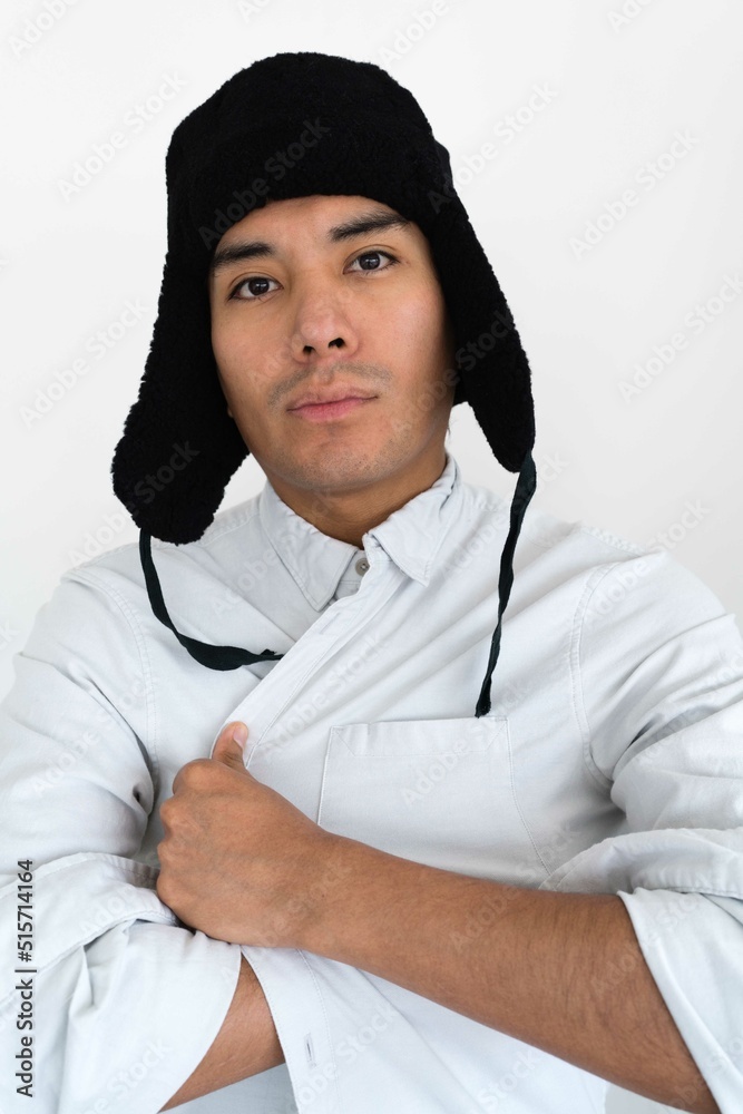 Latin man showing emotion wearing a trapper hat Latin man showing emotion wearing a trapper hat