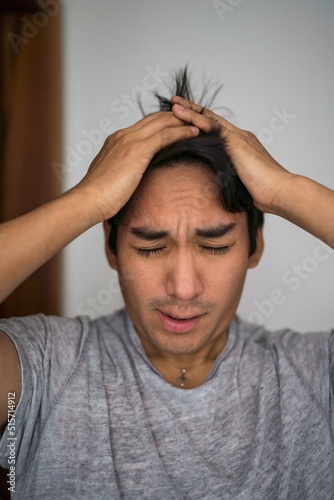 Sleepy Latin man touching his hair