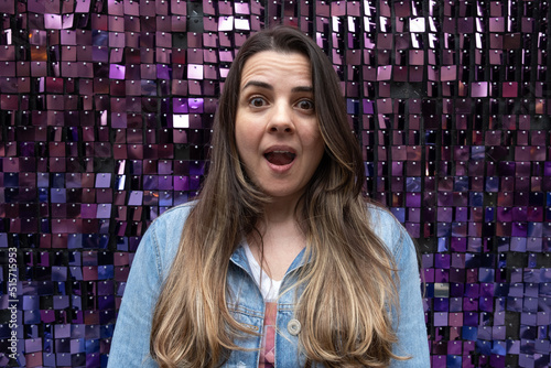 Woman looking amazed on a background with bright purple squares