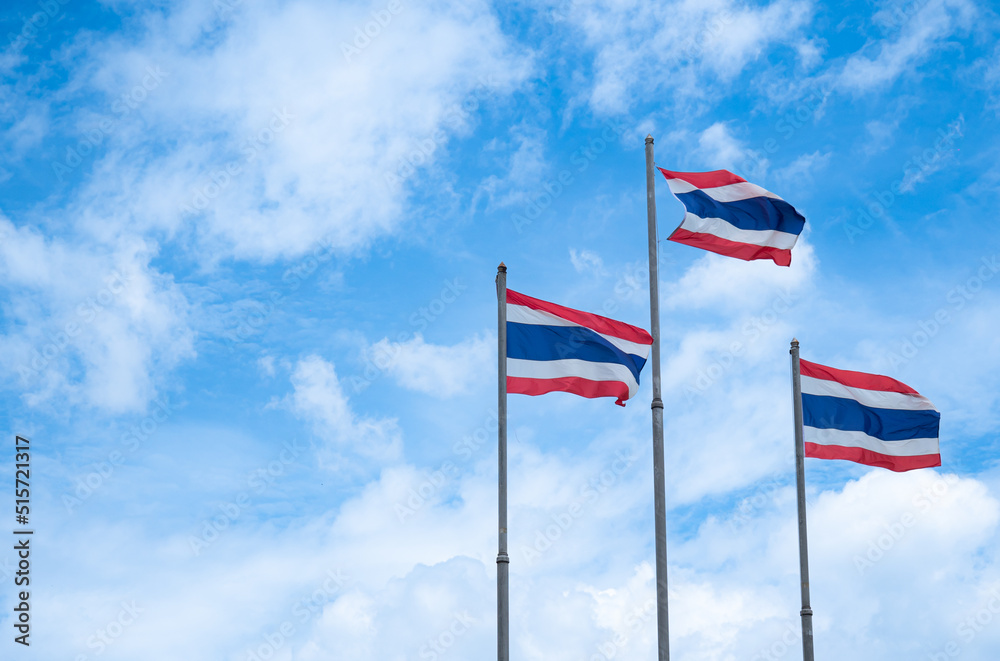 The flag of Thailand on a high pole with a bright sky and white clouds background. The flag of Thailand on a high pole with a bright sky and white clouds background.