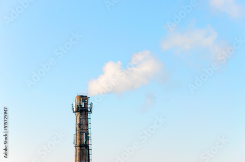 Smoke emission from pipe against a blue sky. © Oleksandr