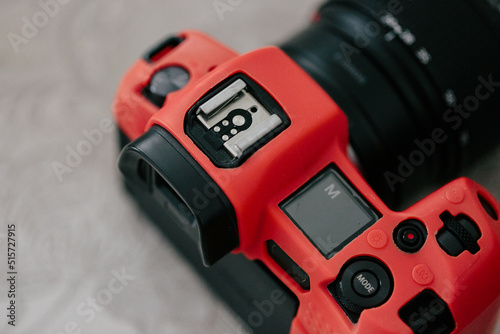 Mirrorless camera in a red silicone case, close-up. Mode m on the scoreboard. View from above
