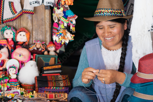 Latin woman smiling and weaving with wool in a handicraft shop