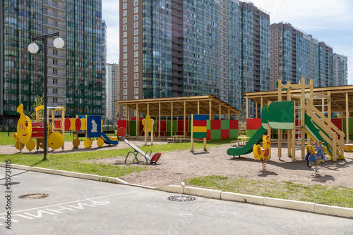 Children's playground in a modern complex of apartment buildings on a sunny day. The territory of the kindergarten.With outdoor amenities © AndreyZayats