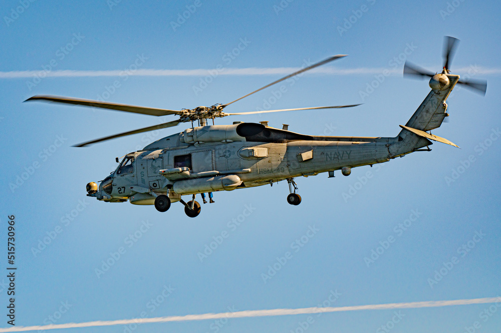 A navy helicopter escorting ships into the harbor in San Diego, California. A navy helicopter escorting ships into the harbor in San Diego, California.