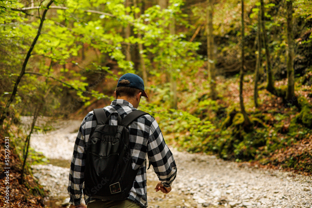 Two friends are traveling through the mountains in the summer with backpacks. In the mountain forest.