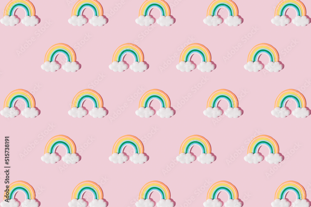 Small colorful rainbow cookie with clouds. Pattern. Pink background. Small colorful rainbow cookie with clouds. Pattern. Pink background.