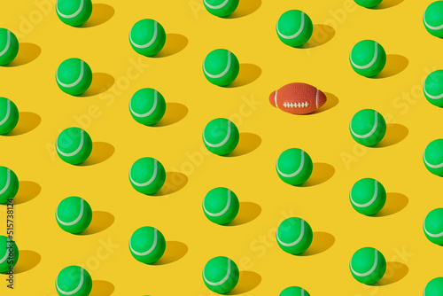 Arranged of green rubber tennis balls and one rugby ball on yellow pastel background. Pattern.
