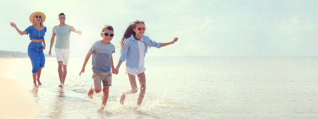 Happy family at beach on sunny summer day, space for text. Banner design