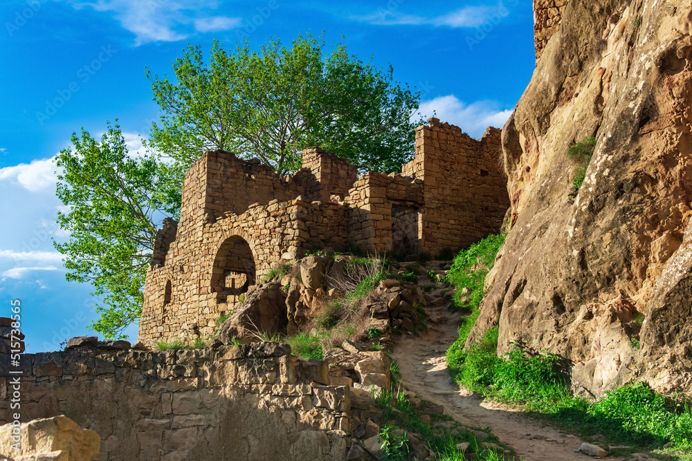 ruins of walls of houses on a cliff in the abandoned village of Gamsutl