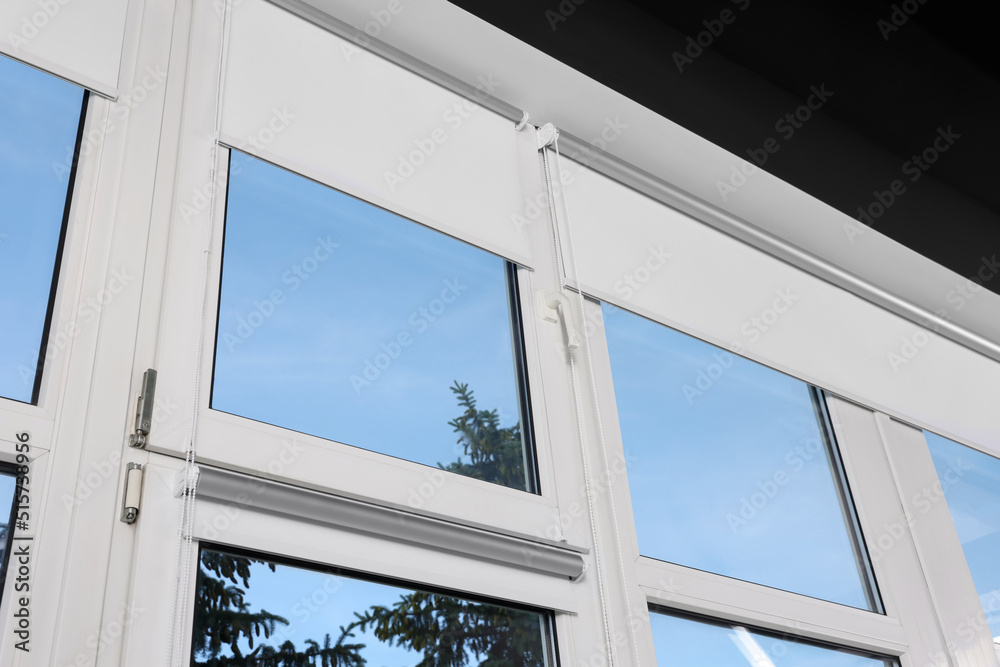 Window with open white roller blinds indoors, low angle view Window with open white roller blinds indoors, low angle view