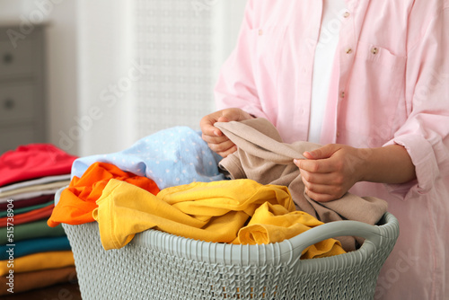 Woman with basket full of clean laundry indoors, closeup