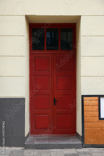 Entrance of house with beautiful red door and transom window