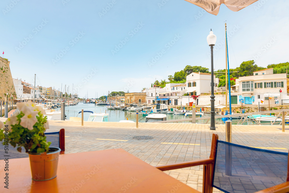 View from a seaside cafe table of boats in the Mediterranean port city of Ciutadella de Menorca, Spain, on the Balearic island of Menorca.