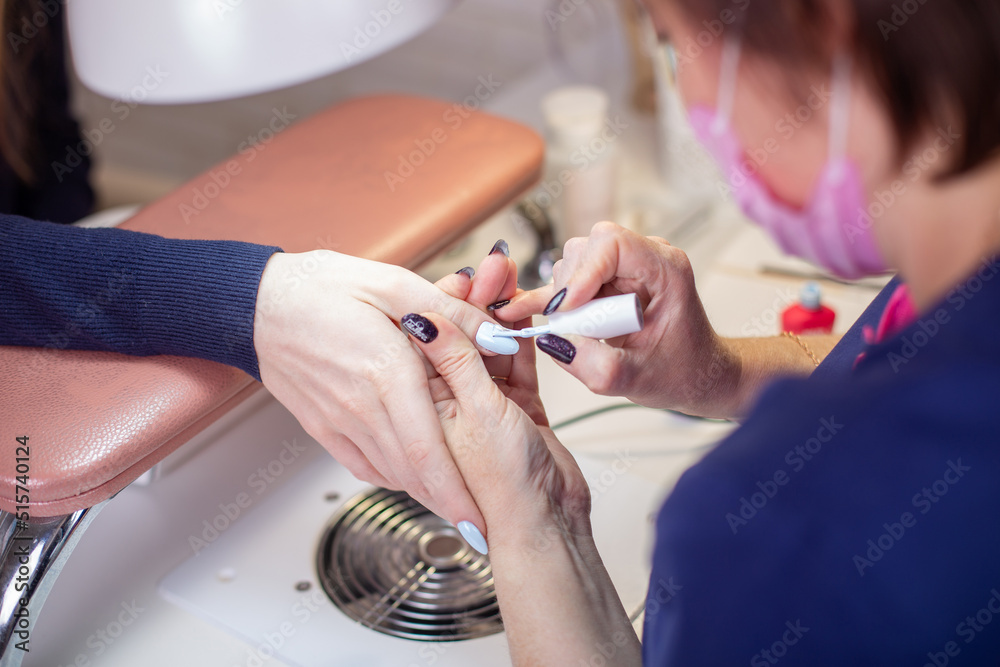 Manicure master applying gel polish on client's nails in beauty salon
Manicure master applying gel polish on client's nails in beauty salon