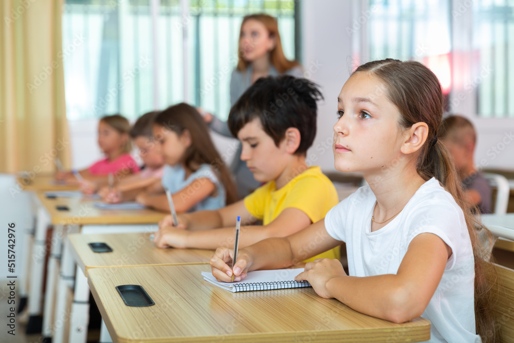 Schoolgirl sitting in classroom during lesson in elementary school. High quality photo