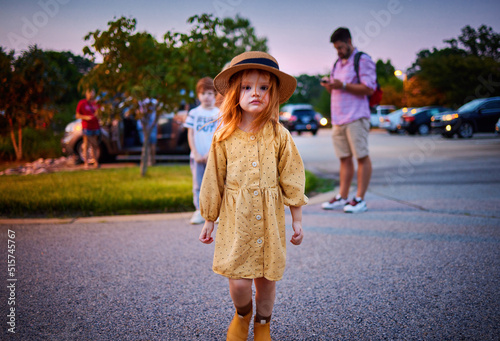 portrait of redhead little baby girl standing on the street
