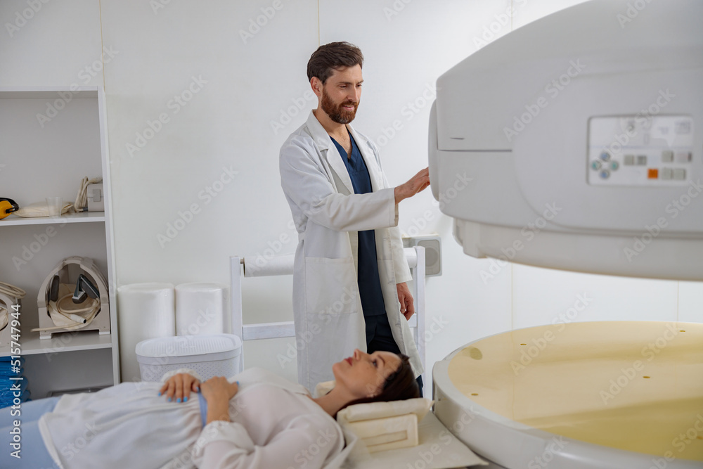 Radiologist controls MRI or CT or PET Scan with female patient undergoing procedure Radiologist controls MRI or CT or PET Scan with female patient undergoing procedure