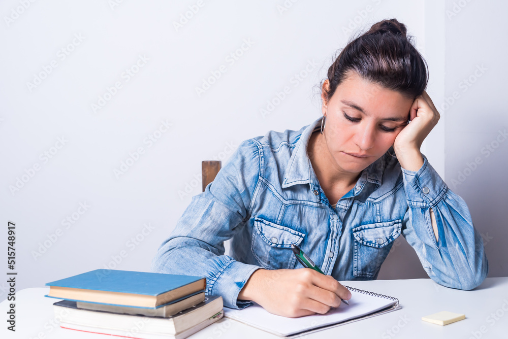 latina woman, studying at home, seated, wearing glasses, holding head, sad and bored, college concept latina woman, studying at home, seated, wearing glasses, holding head, sad and bored, college concept