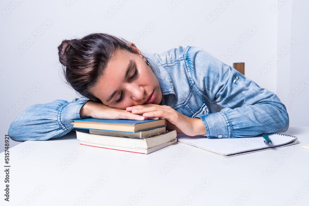 latina woman, studying at home, sitting, asleep on top of her books, dream, college concept latina woman, studying at home, sitting, asleep on top of her books, dream, college concept