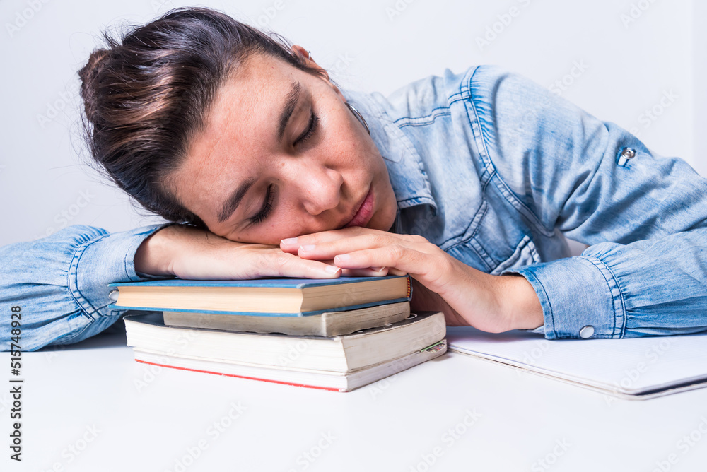 latina woman, studying at home, sitting, close up, asleep on top of her books, dreaming, college concept latina woman, studying at home, sitting, close up, asleep on top of her books, dreaming, college concept