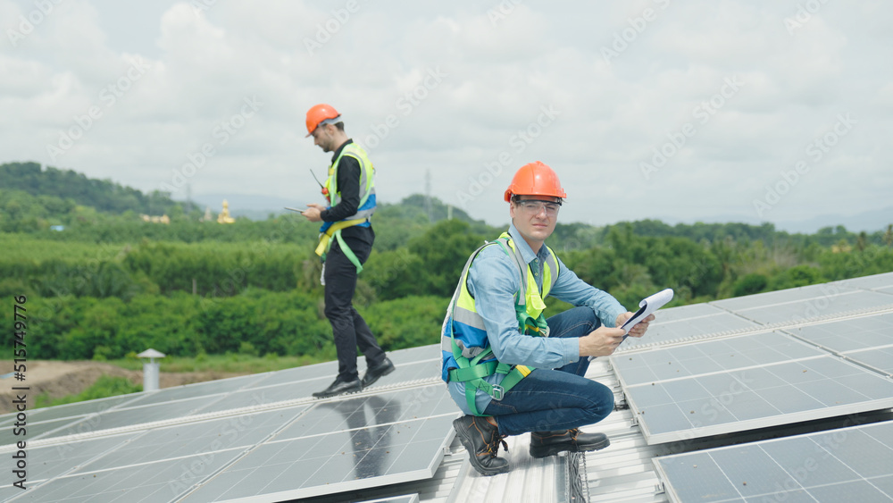 Engineer and construction worker examining solar panels on rooftop. Engineer and construction worker examining solar panels on rooftop.