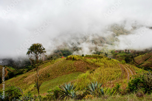 Panoramic view at rhe dirt road and the village Ucumari located on highlands at ecuadorian Andes at rainy cloudy day. Ecuador. Azuay province, Nabon canton.