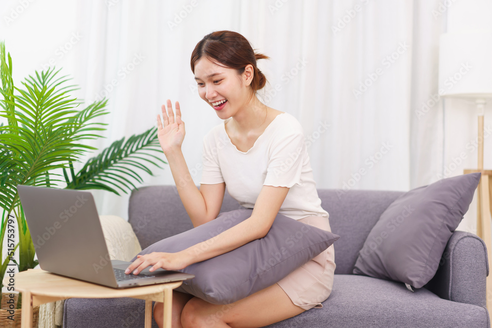 Lifestyle in living room concept, Asian woman makes greeting gesture with colleague on video call Lifestyle in living room concept, Asian woman makes greeting gesture with colleague on video call