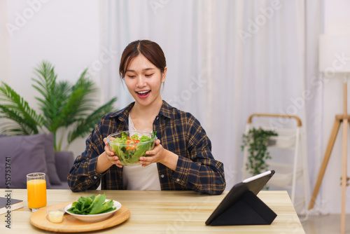 Lifestyle in living room concept  Young Asian woman excited while holding bowl of vegetable salad