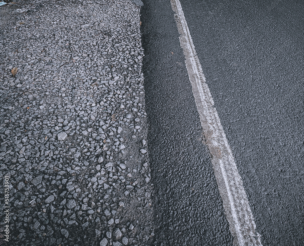 Fototapeta premium Side by side asphalt road and gravel road background