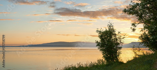 Fotografiet Copyspace and scenic landscape of a lake or river and mountains north of polar and arctic circle in Norway during sunset